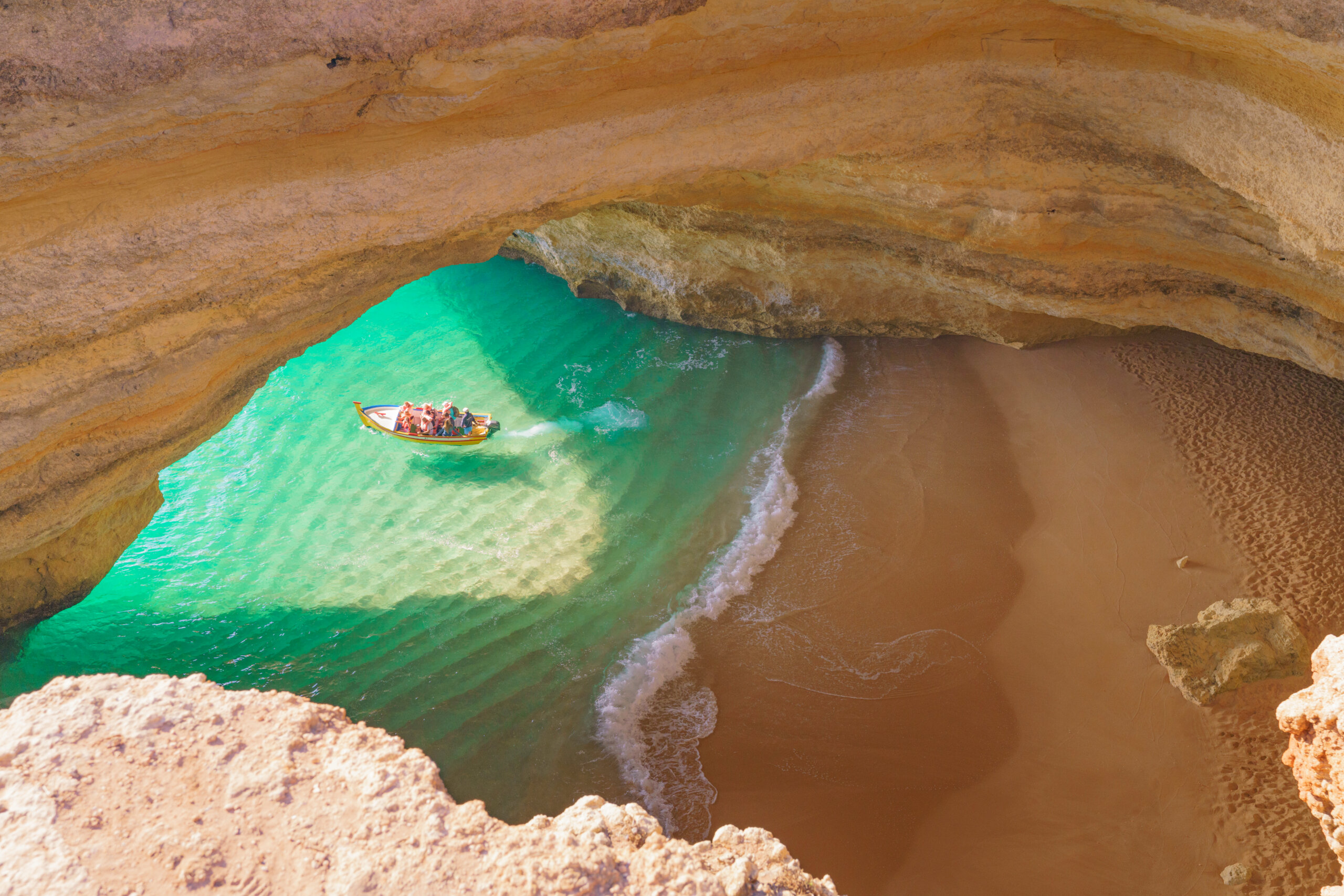 En båd med turister der forlader en grotte på Algarvekysten